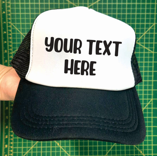 a black and white custom trucker hat with the example text saying your text here