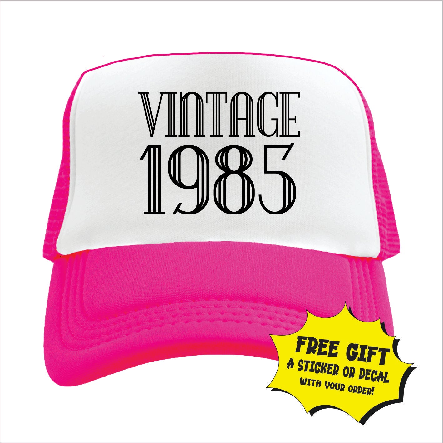 Pink and white trucker hat cap with 'VINTAGE 1985' printed in black text on the front panel.