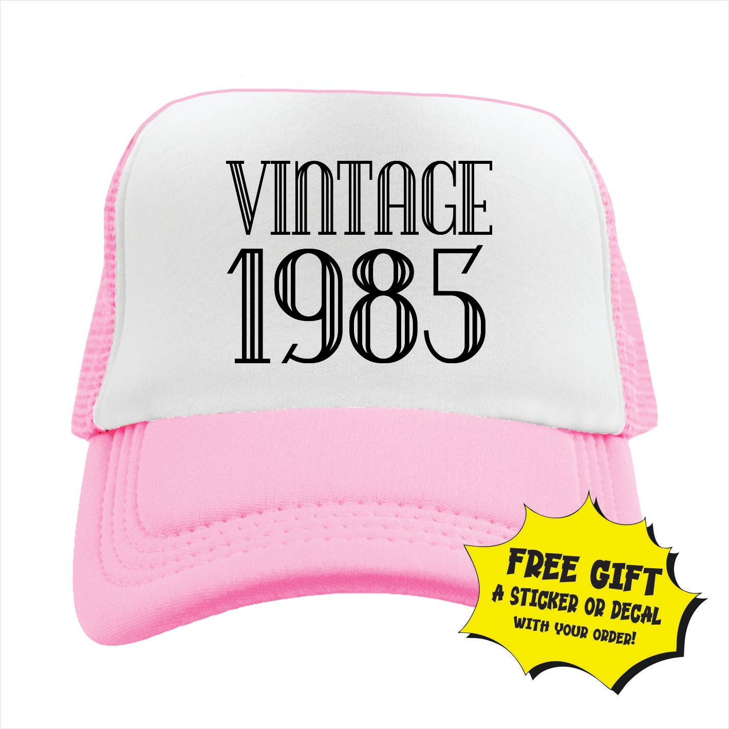 Light pink and white trucker hat cap with 'VINTAGE 1985' printed in black text on the front panel.