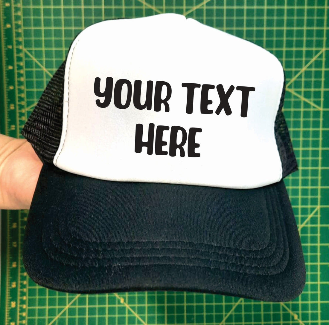 a black and white custom trucker hat with the example text saying your text here