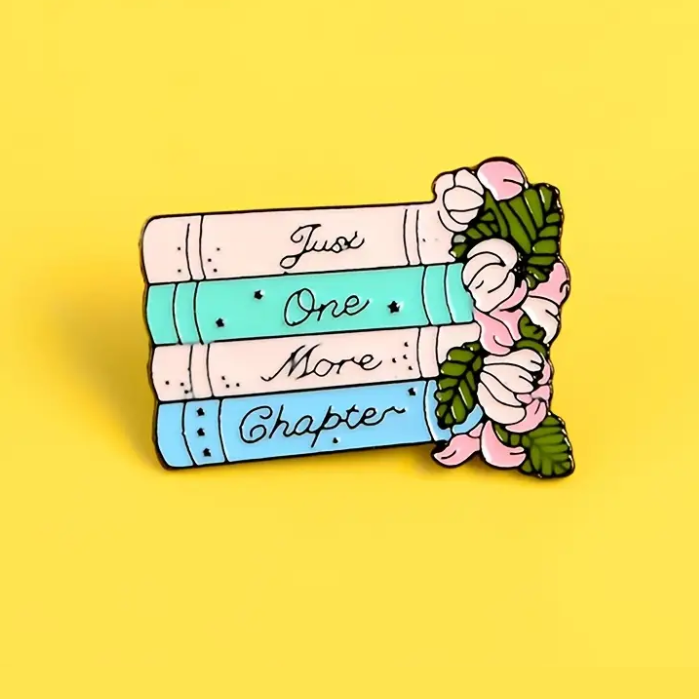 enamel pin showing 4 books, flowers and message just one more chapter ecorootstore