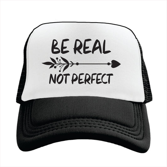 Black and white trucker hat cap with 'BE REAL NOT PERFECT' printed in black text on the front panel.