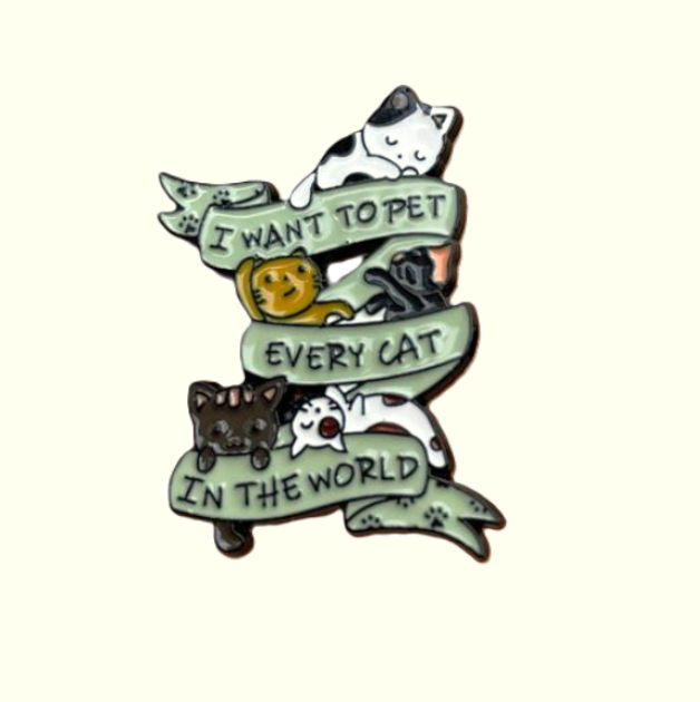 enamel pin with many little cats saying i want to pet every cat in the world