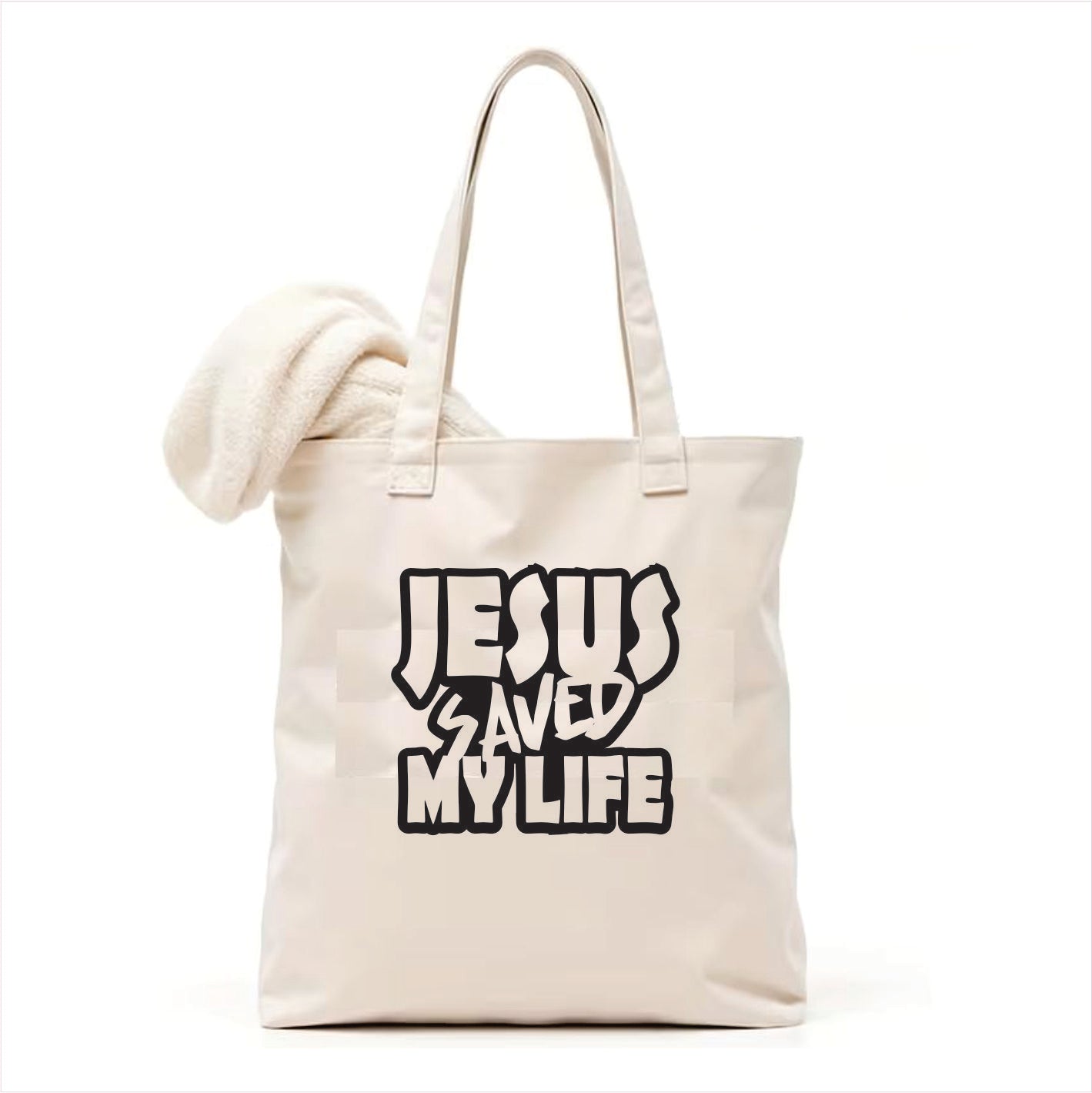 white tote bag with 'Jesus Saved My Life' text on a white background