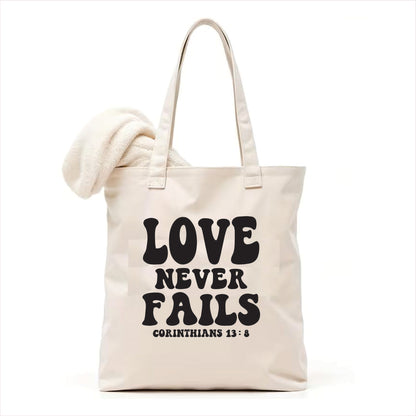 white tote bag with 'Love Never Fails' text on a white background