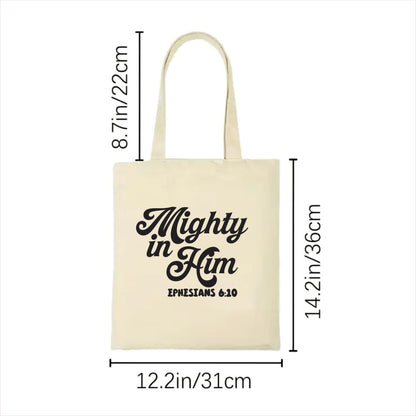 white tote bag with 'Mighty in Him' text and measurements on a white background