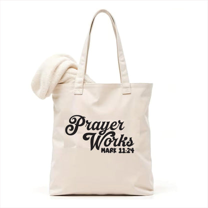 white tote bag with 'Prayer Works Mark 11:24' text on a white background