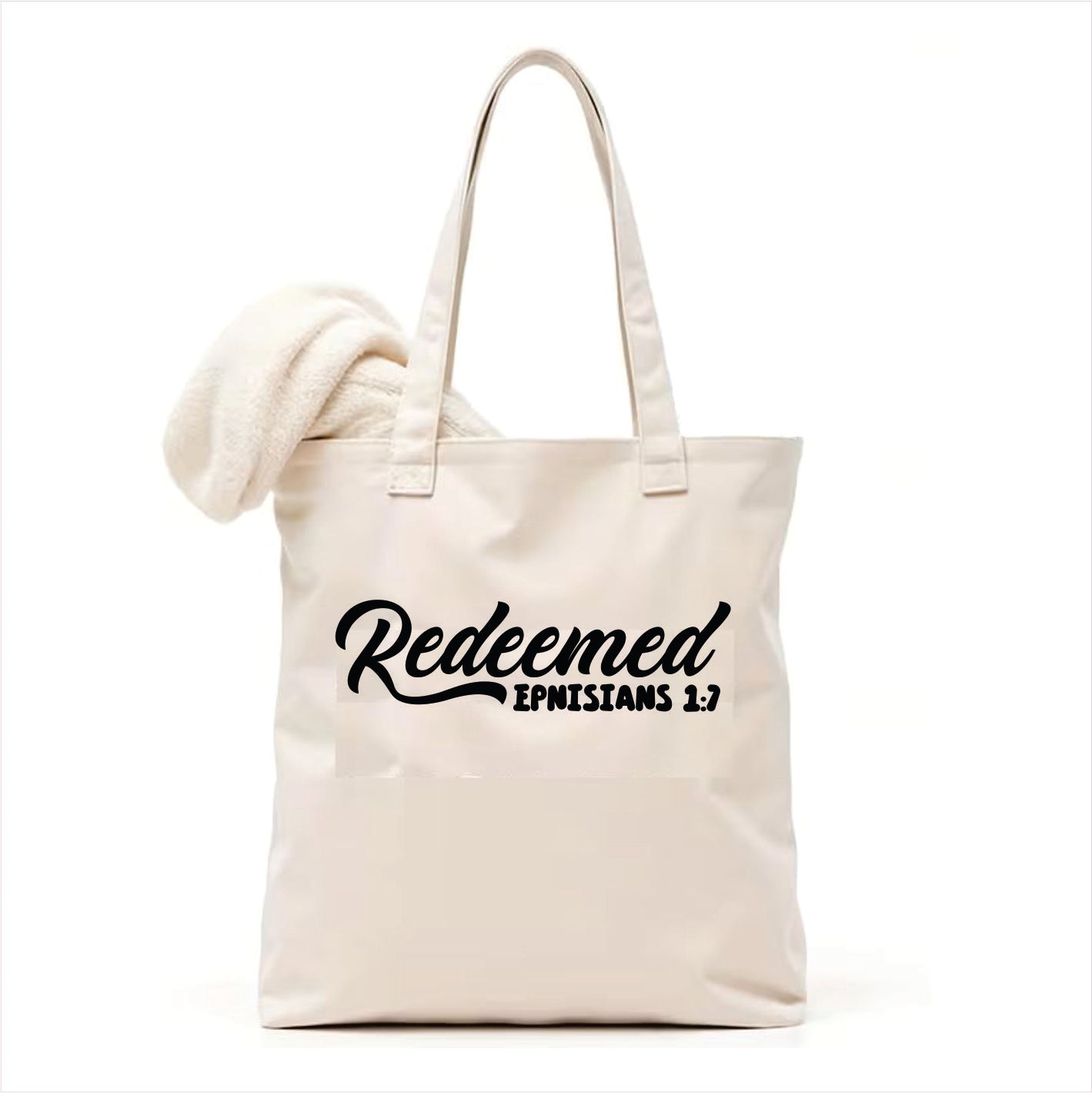 white tote bag with 'Redeemed Ephesians 1:7' text on a white background