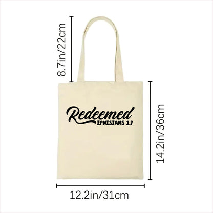 white tote bag with 'Redeemed Ephesians 1:7 text and measurements on a white background
