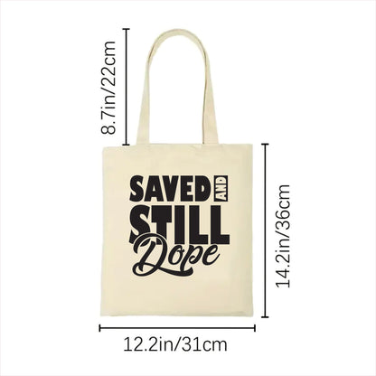 white tote bag with 'Saved and Still Dope' text and dimensions on a white background