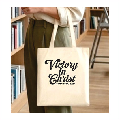 Person holding a tote bag with 'Victory in Christ' text in a library setting