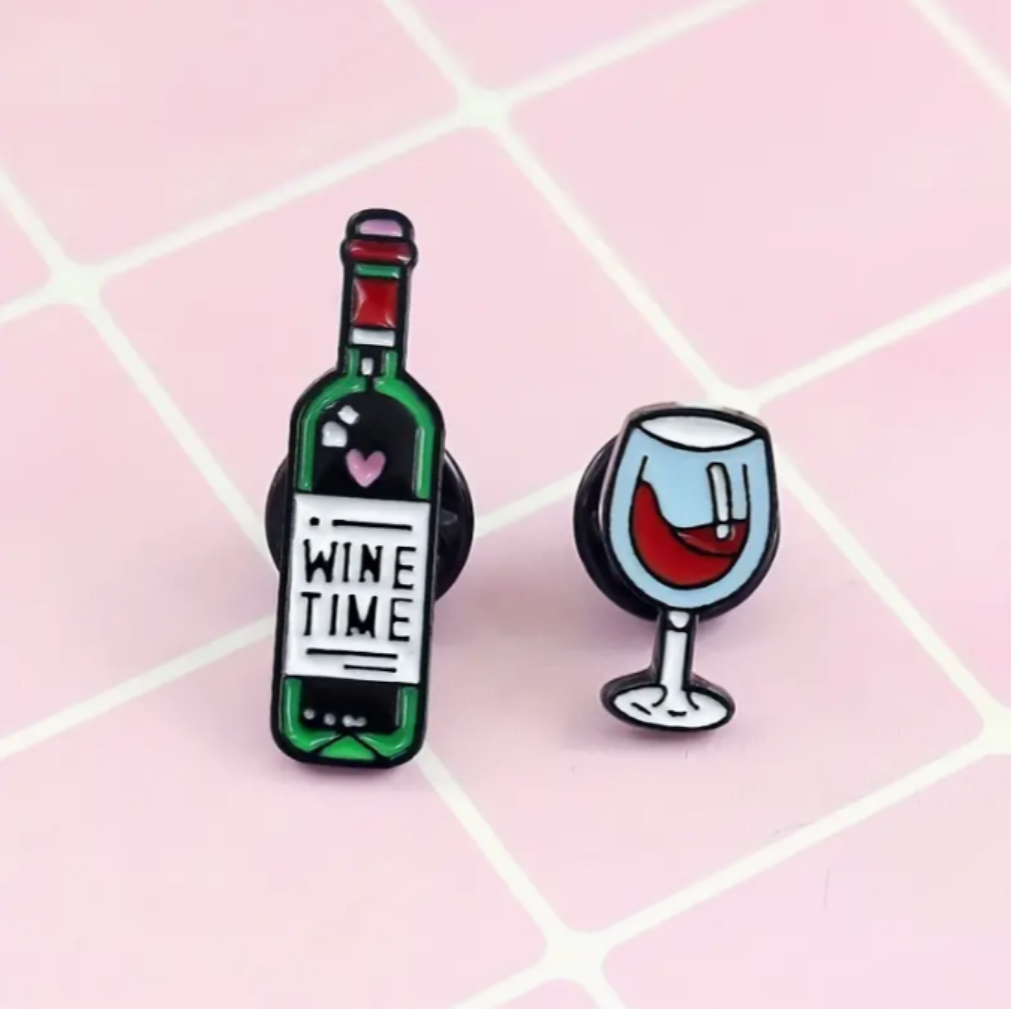 2 enamel pins with designs of a bottle of wine and a glass of wine